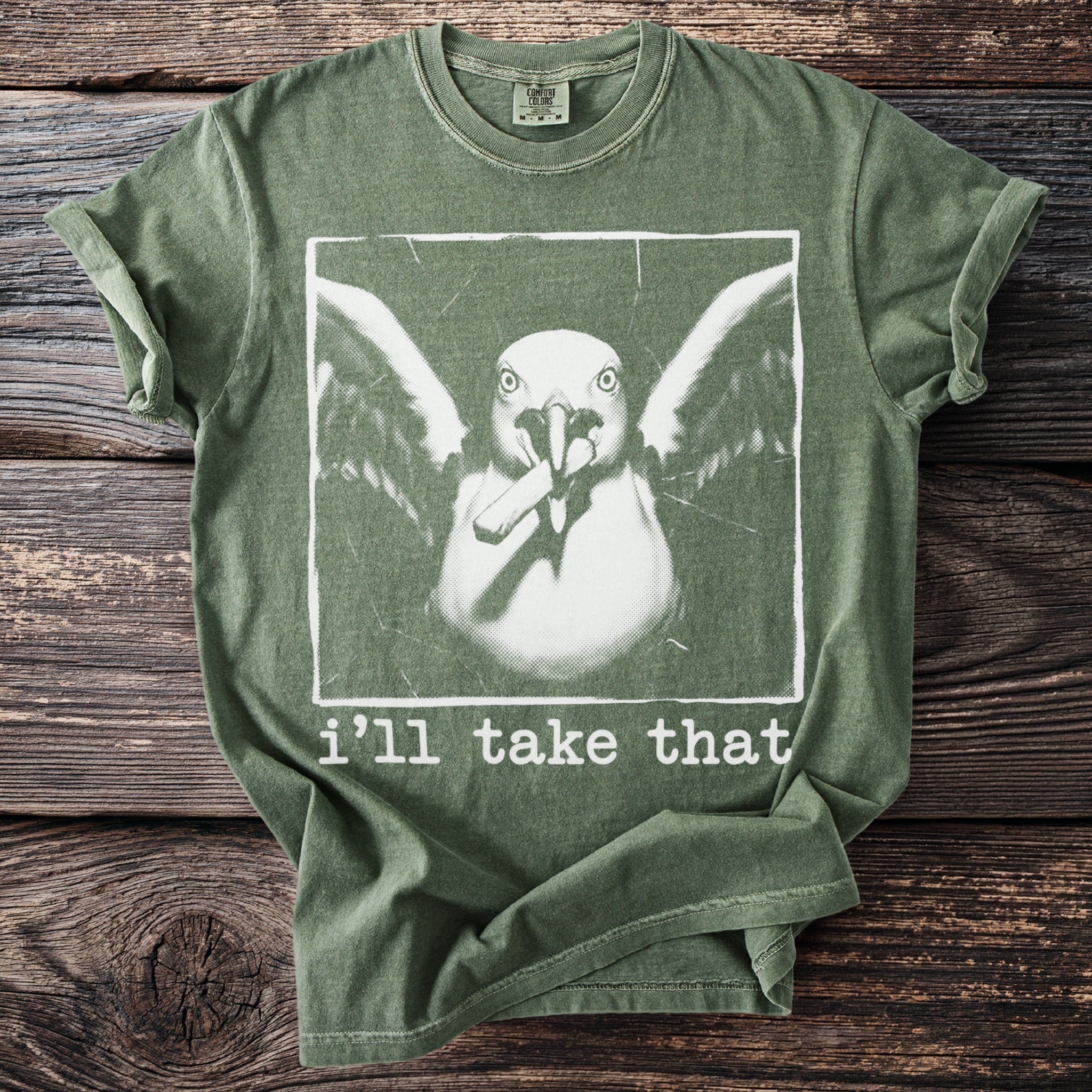 Green t-shirt with a graphic of a seagull holding a cigarette and text "i'll take that".