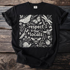 Black t-shirt with a white line art design of insects and plants, reading "respect the locals".