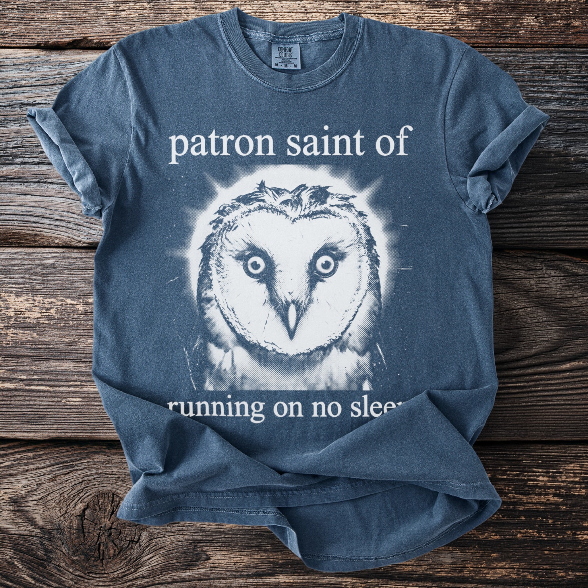 Shirt with owl graphic and text "patron saint of running on no sleep".