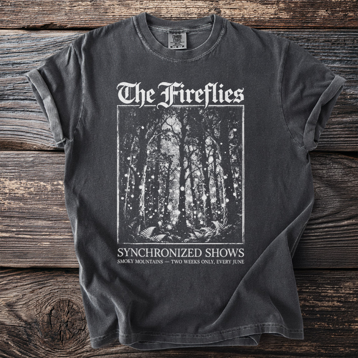 Dark grey t-shirt with "The Fireflies" and forest scene on front.