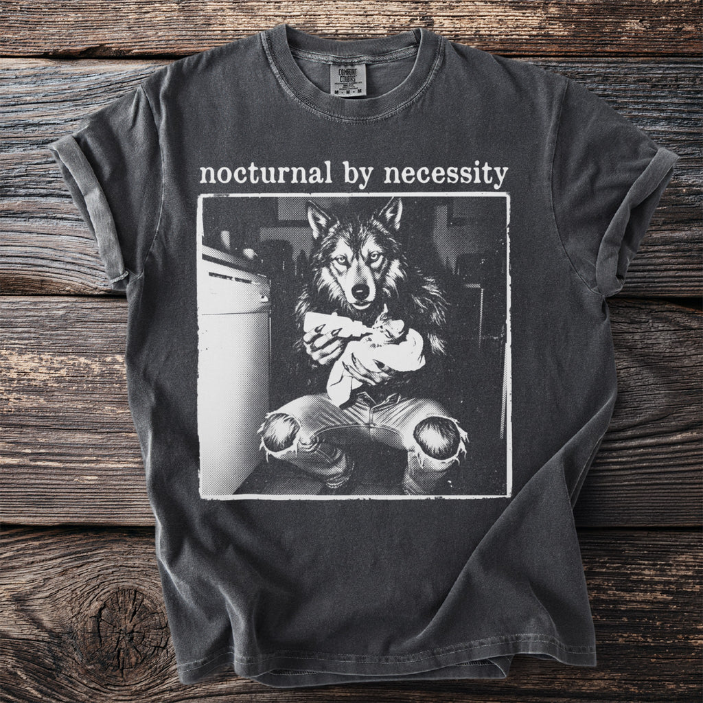 T-shirt with "nocturnal by necessity" text and a black and white graphic of a wolf feeding a kitten.
