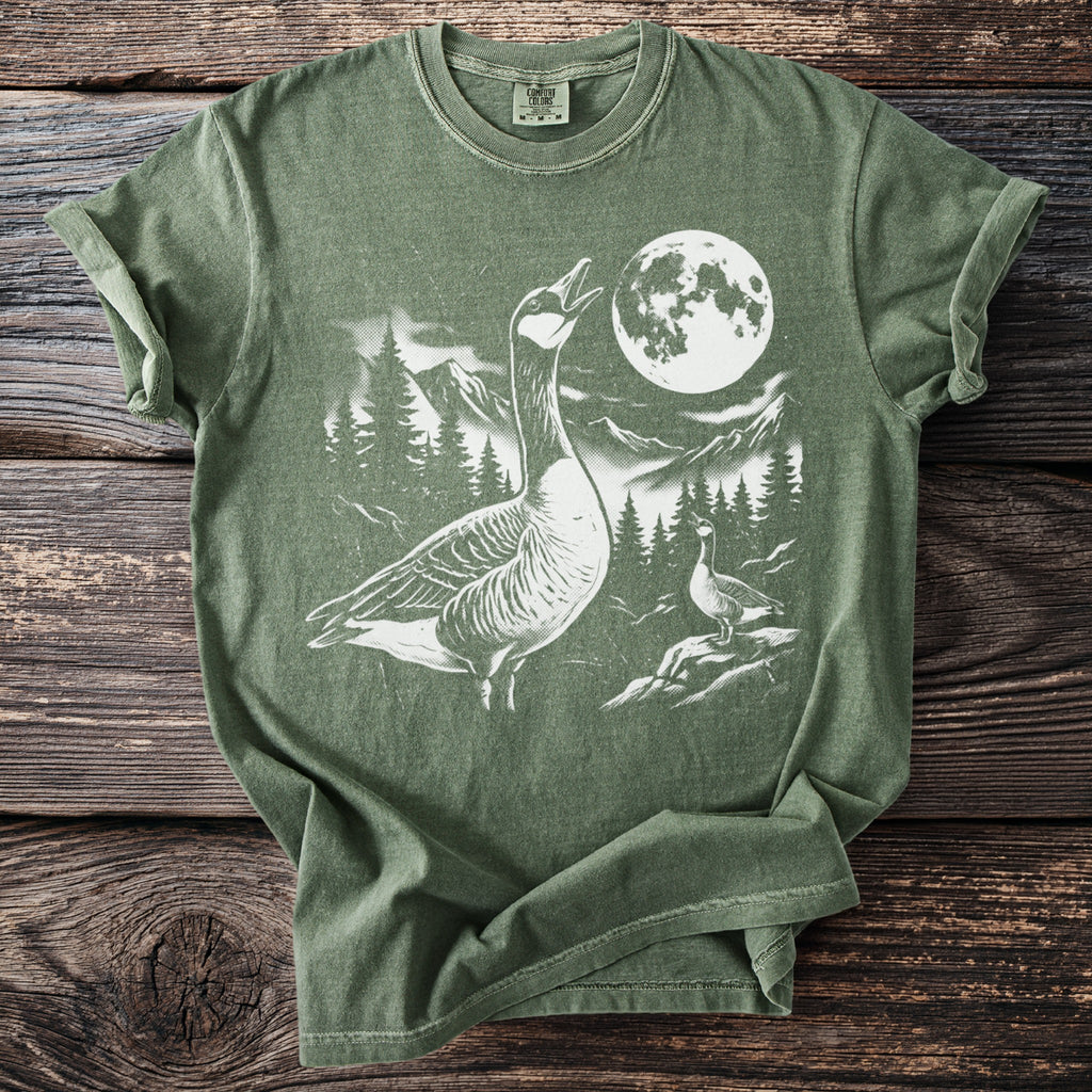 Green t-shirt with white graphic of geese, moon, trees, and mountains.
