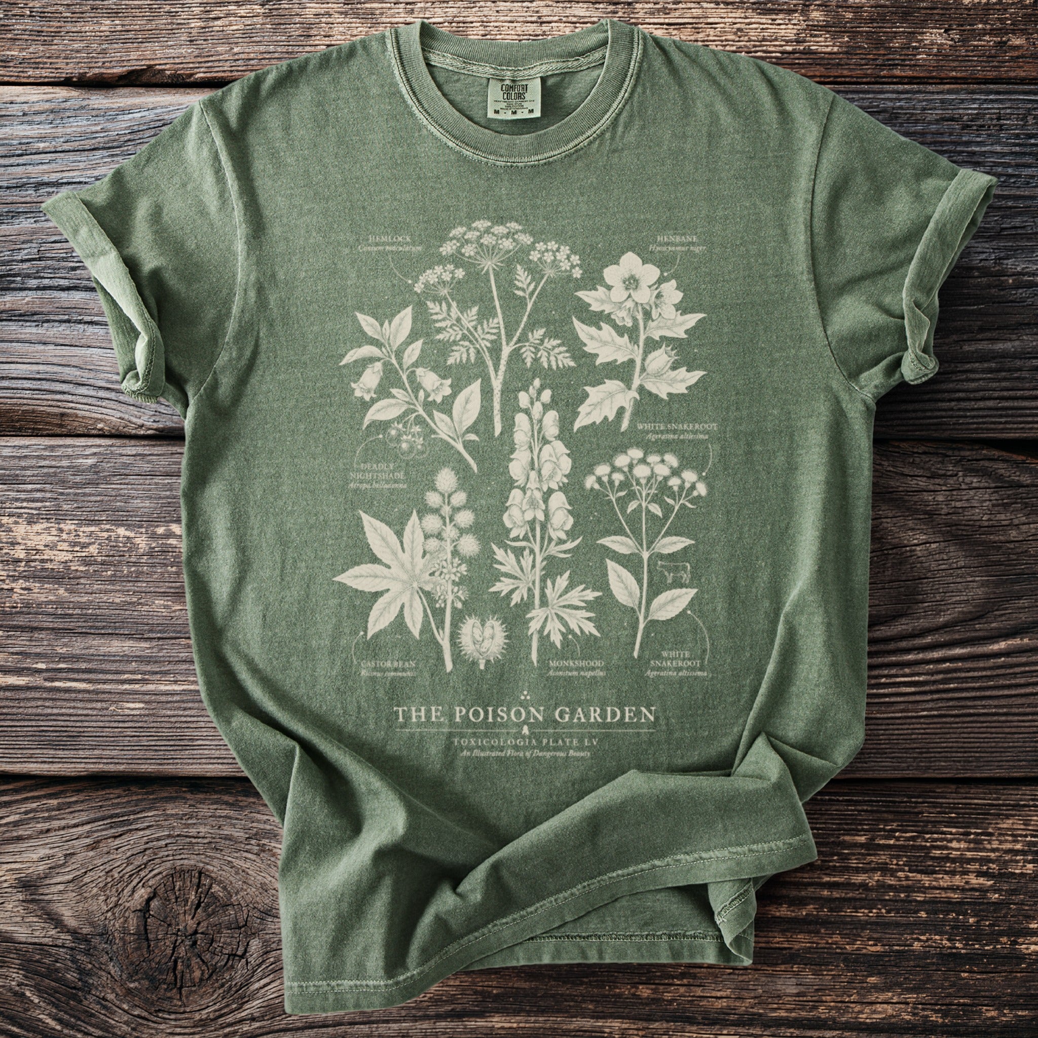 Green t-shirt with an illustration of toxic plants and "The Poison Garden" text.