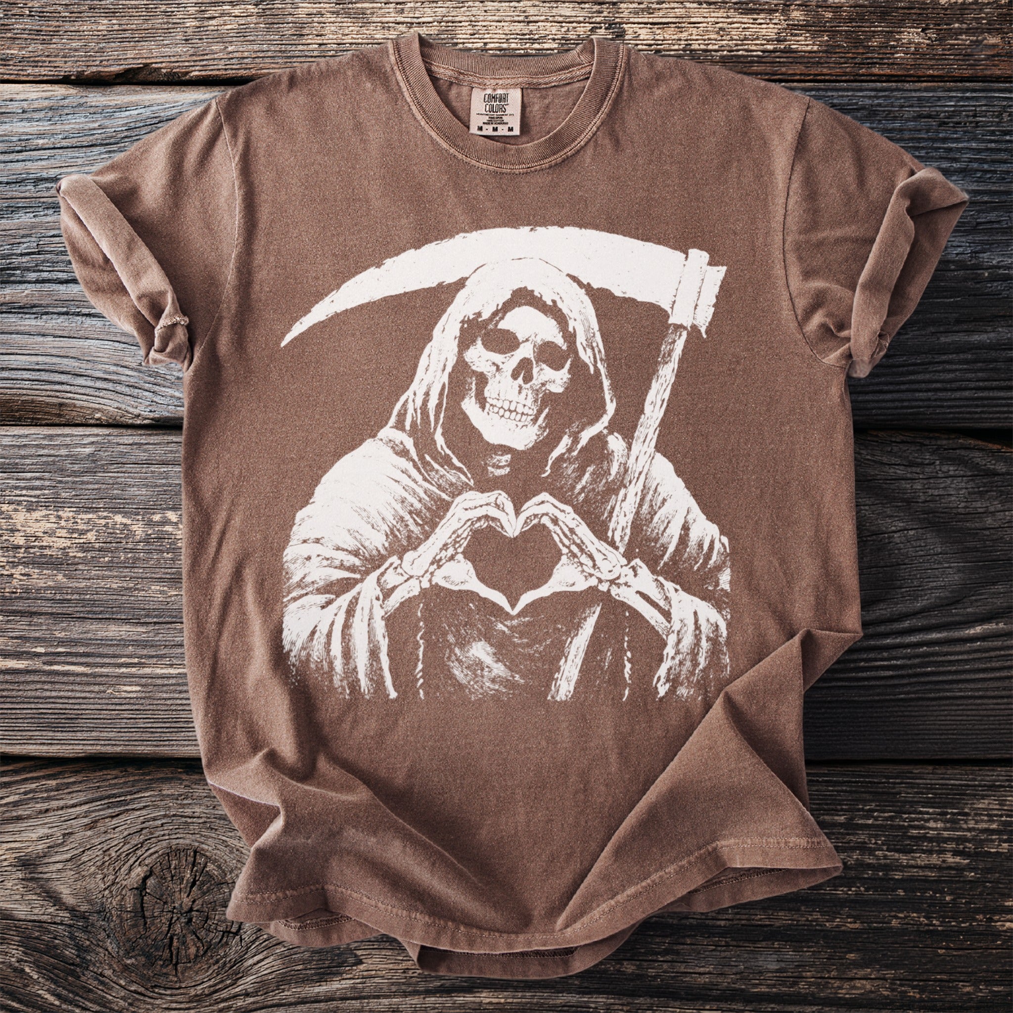 Brown t-shirt with grim reaper making heart shape with bony hands.