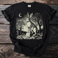 Black t-shirt with a vintage-style illustration in cream of a rabbit on a tombstone under a crescent moon.