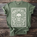 Green t-shirt with white graphic of a skull, bones, flowers, and text saying "ALL PLANTS ARE EDIBLE SOME ONLY ONCE".