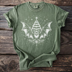 Green t-shirt with white graphic of a bat with Christmas tree wings and snowflakes.