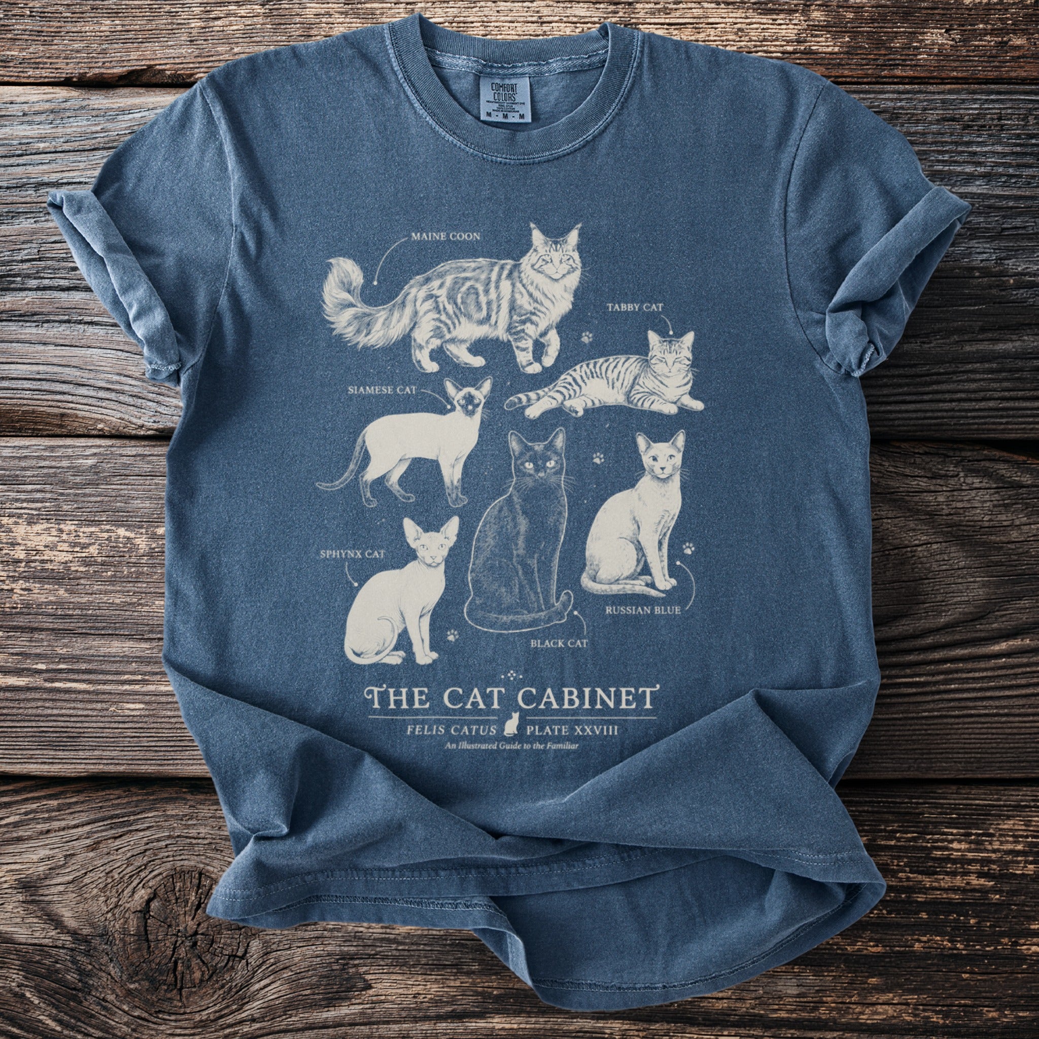 Blue t-shirt with illustrated cat breeds titled "The Cat Cabinet."