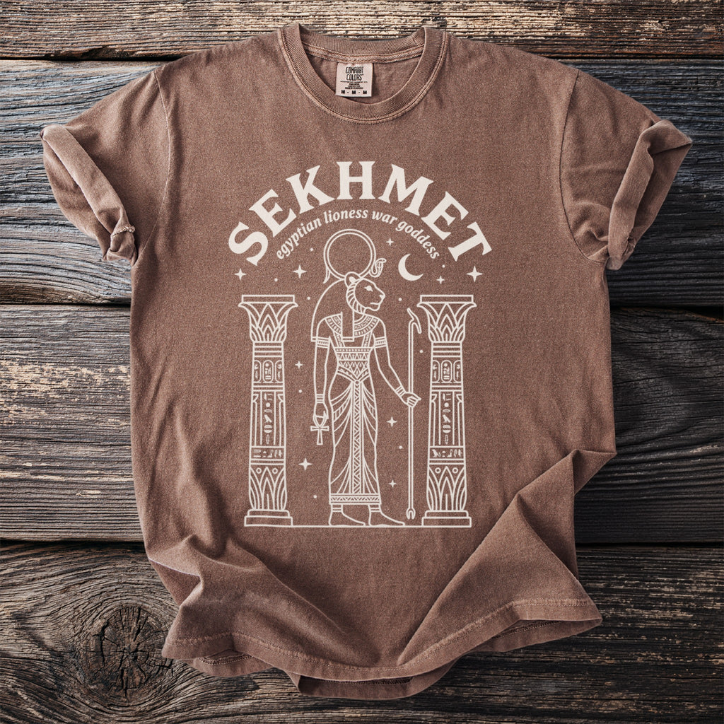 Brown t-shirt with white line art of Sekhmet, Egyptian lioness war goddess.