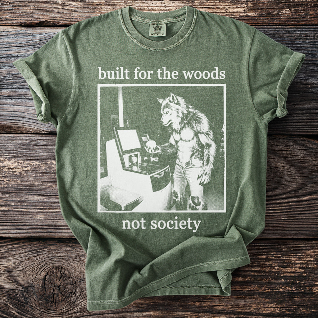 Green t-shirt with white text "built for the woods not society" and a graphic of a werewolf.