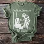 Green t-shirt with white text "built for the woods not society" and a graphic of a werewolf.