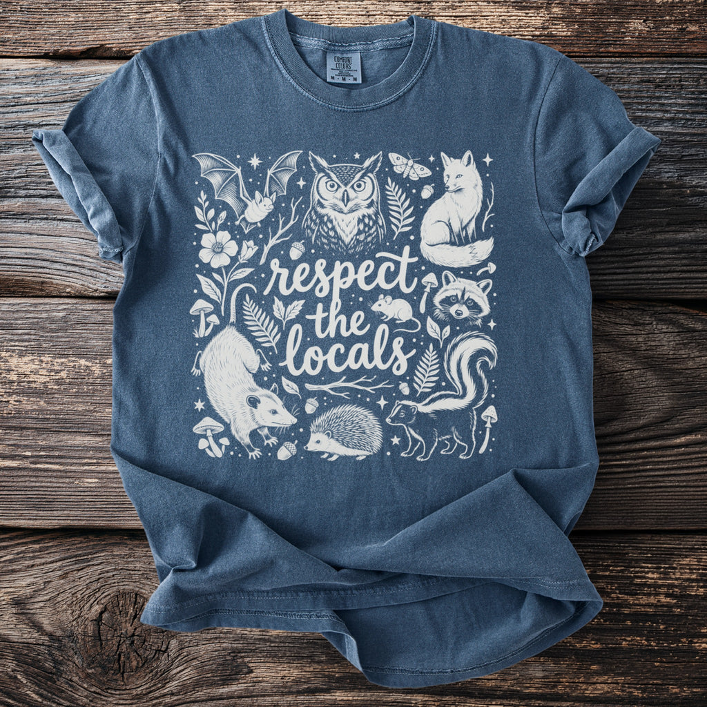 Blue t-shirt with "respect the locals" text and forest animals illustration.