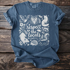 Blue t-shirt with "respect the locals" text and forest animals illustration.