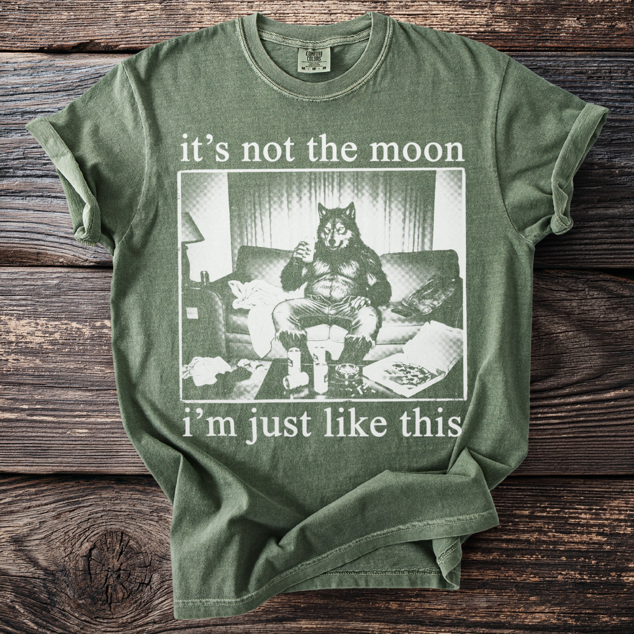 Green t-shirt with a werewolf sitting on a couch with drinks and pizza, reading "it's not the moon i'm just like this".