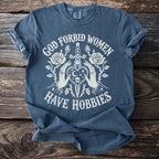 Blue t-shirt with white text and graphic: "God Forbid Women Have Hobbies"