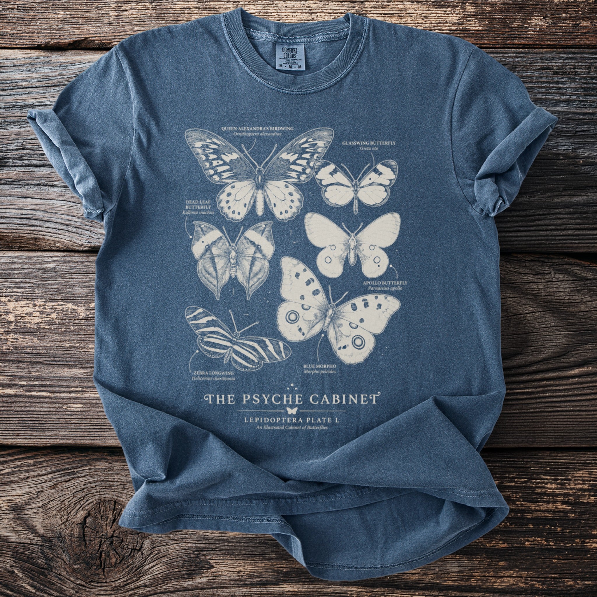 Blue t-shirt with vintage butterfly illustrations and "The Psyche Cabinet" text.