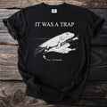 Black t-shirt with IT WAS A TRAP and an engraved Tiktaalik, a lobe-finned fish, hauling itself onto rock, captioned Fig. 1: The Mistake.