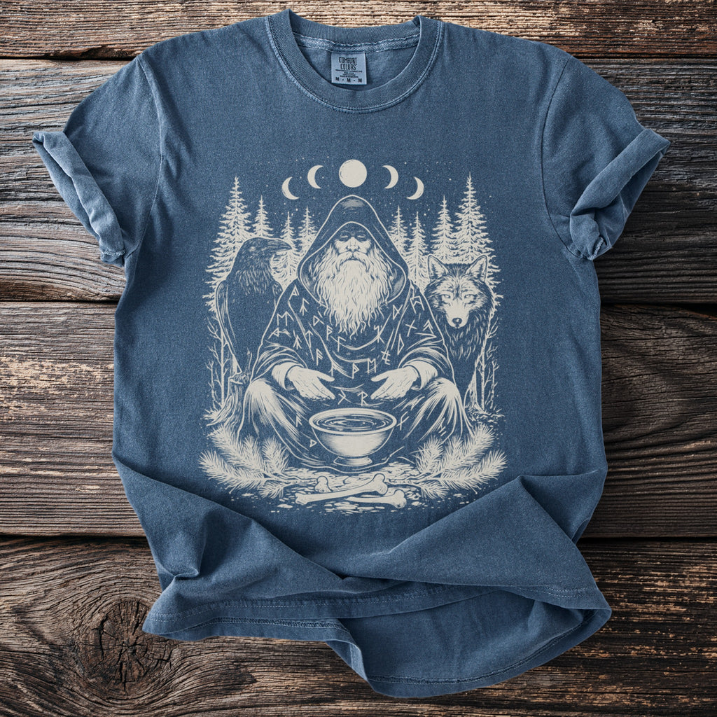 Blue shirt with a print of a hooded, bearded man with a raven and wolf under a moon cycle.