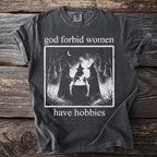 Graphic t-shirt with slogan "god forbid women have hobbies" and image of three witches.
