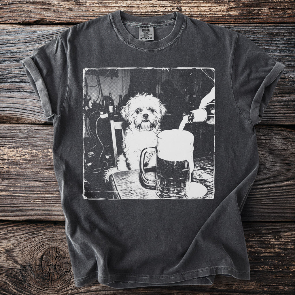 T-shirt print of a small white dog sitting next to a beer mug with foam.