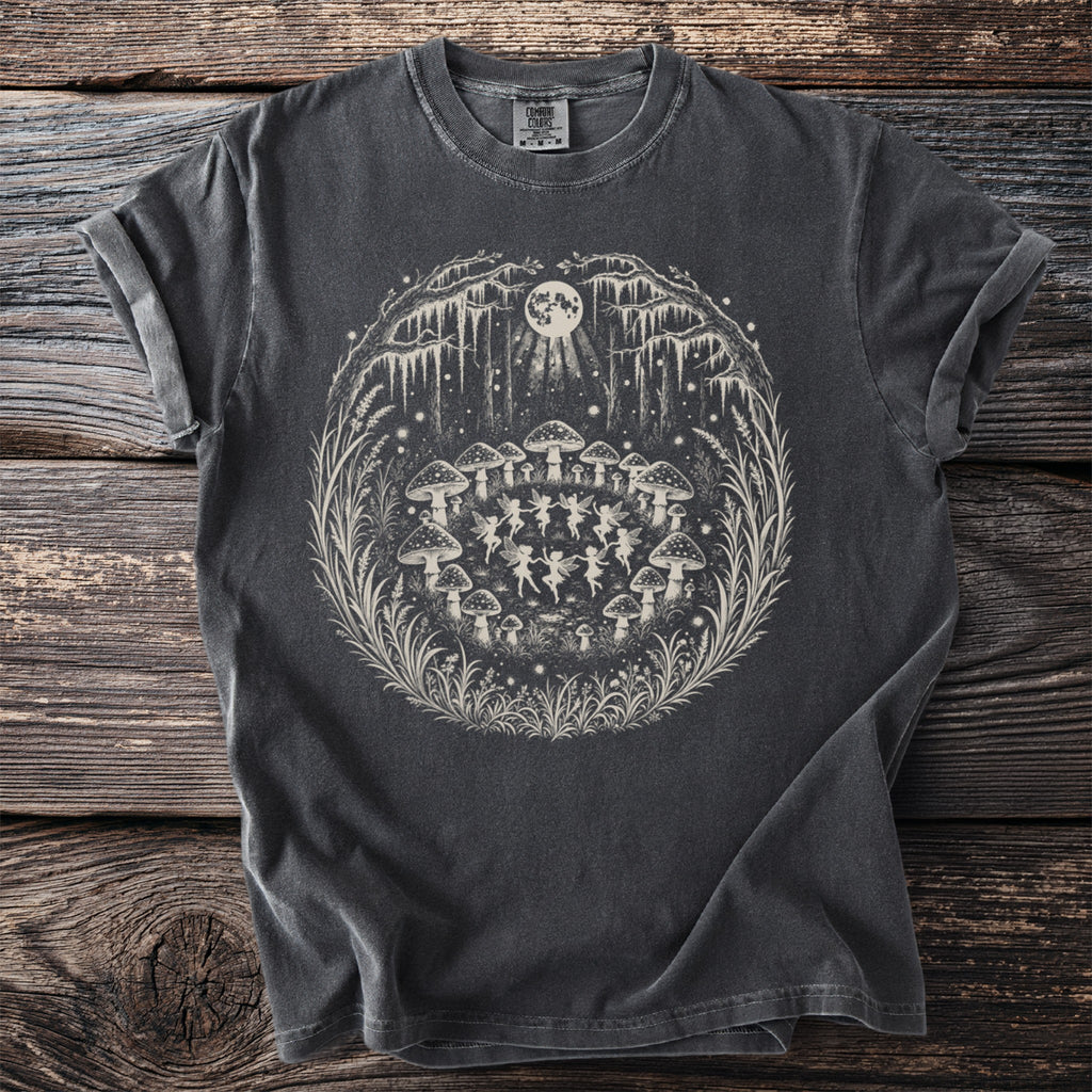 Dark grey t-shirt with white graphic of fairies dancing around mushrooms under a full moon.