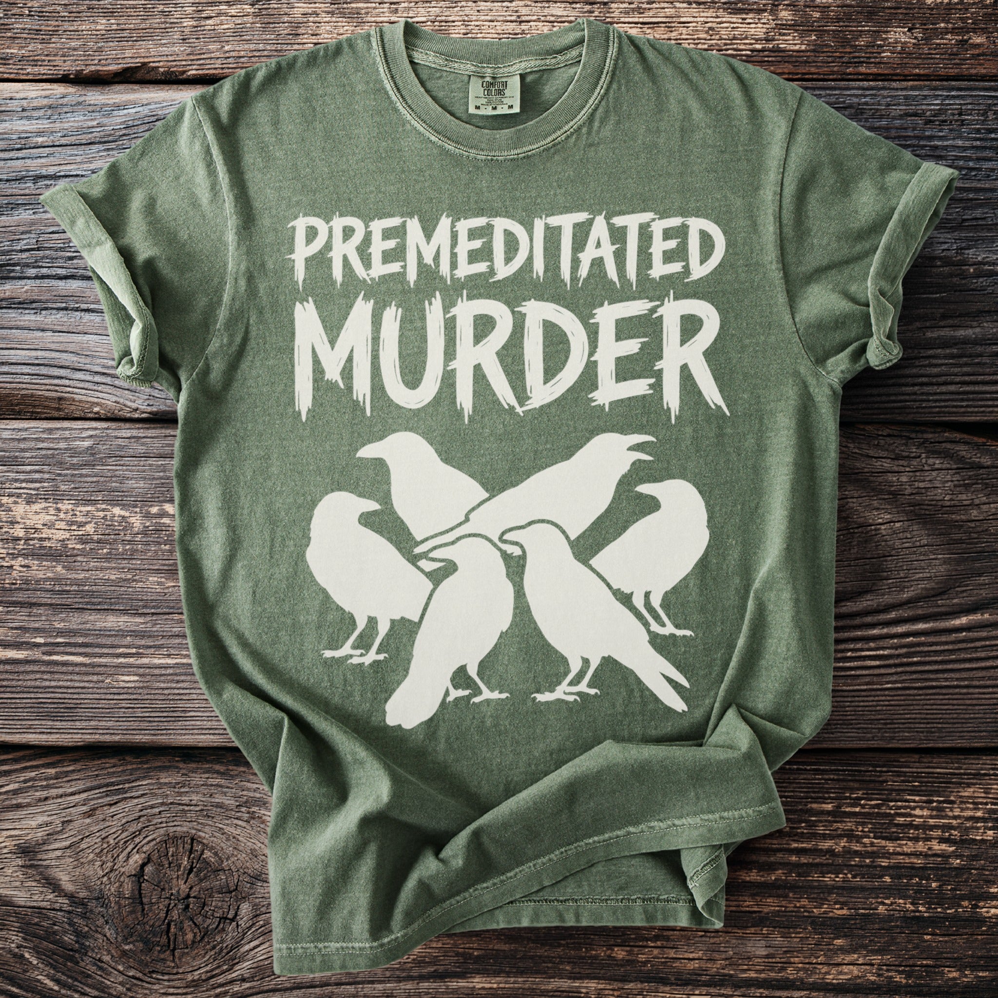 Green t-shirt with "PREMEDITATED MURDER" text and white crow graphics.
