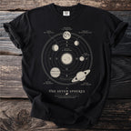 Black t-shirt with celestial spheres diagram featuring sun, moon, and planets.
