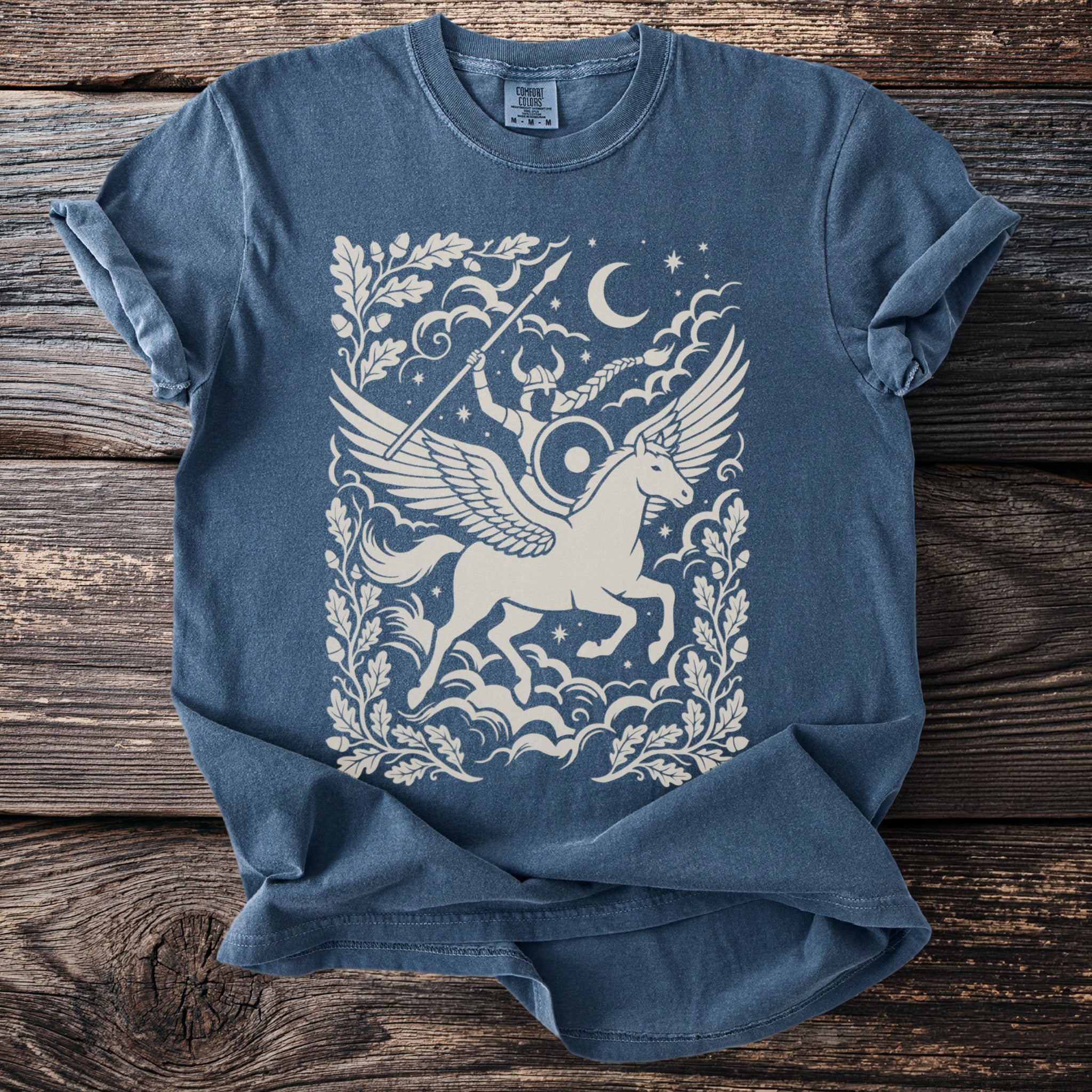 Blue t-shirt with a cream graphic of a winged unicorn and a Viking rider.