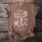 Brown t-shirt with botanical illustration of poisonous plants and text "The Poison Garden".