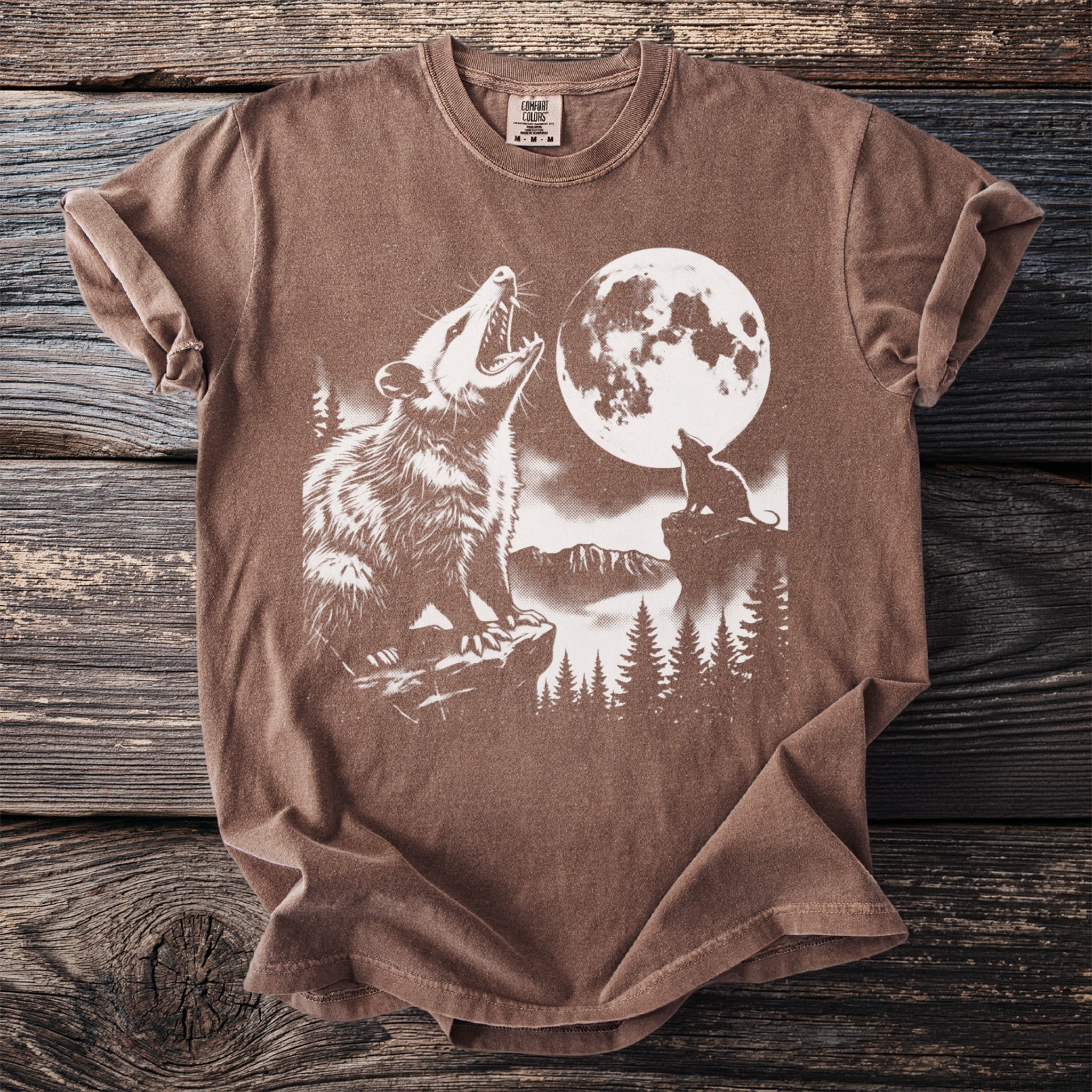 Brown t-shirt with a graphic of two possums howling at the moon.