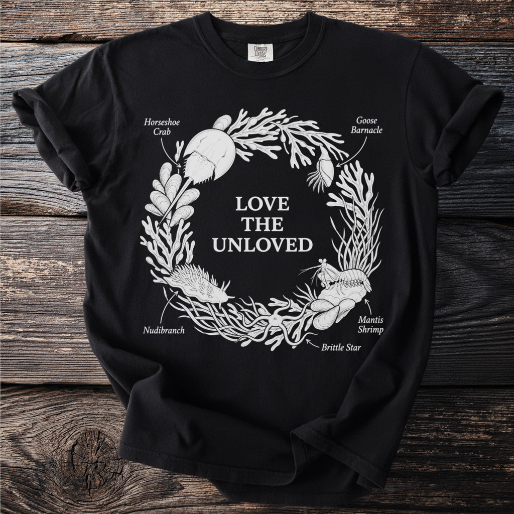 Black t-shirt with white circular design of marine life and text.