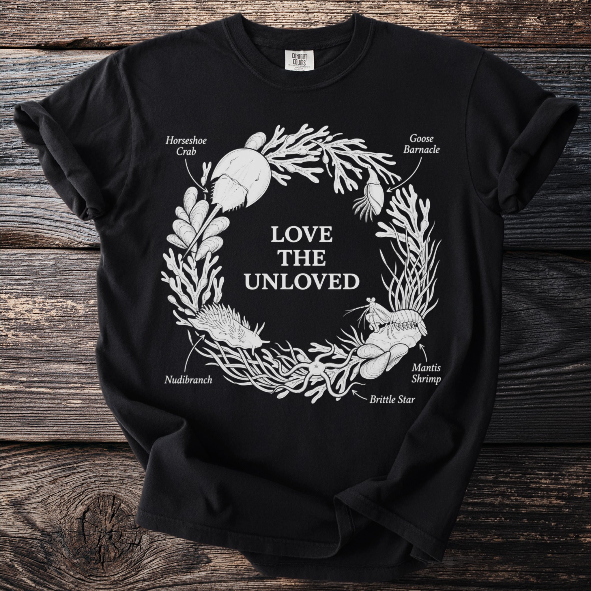 Black t-shirt with white circular design of marine life and text.