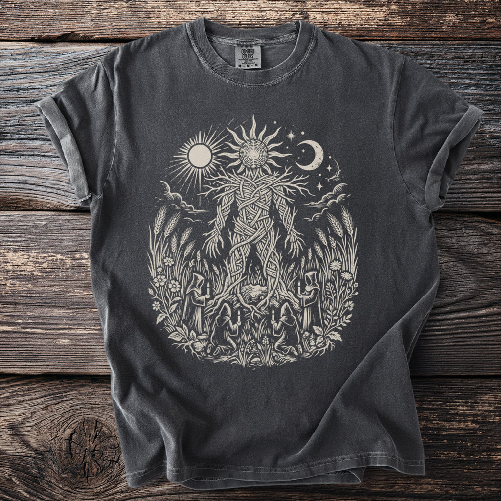 Dark grey t-shirt with a light-colored print of a woven figure surrounded by nature and figures.