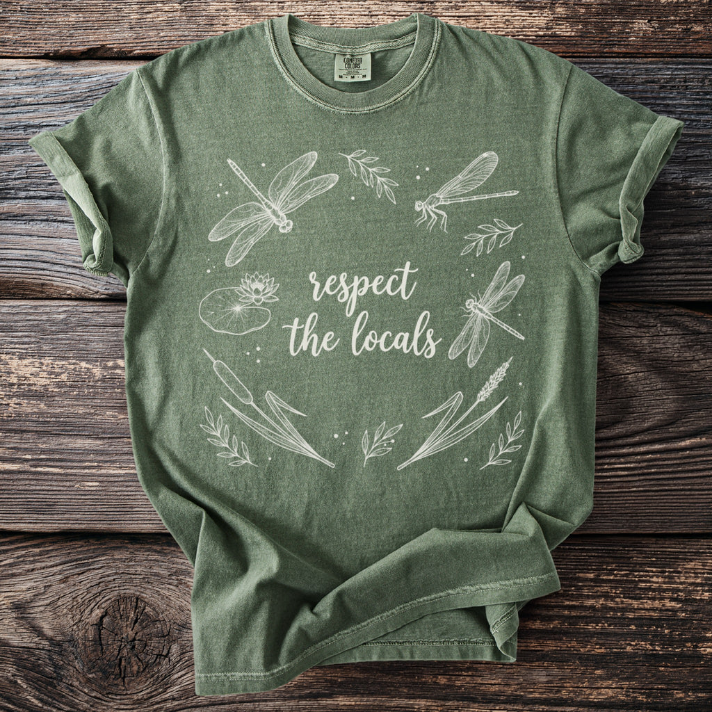 Green t-shirt with white dragonfly and nature graphic with text "respect the locals".