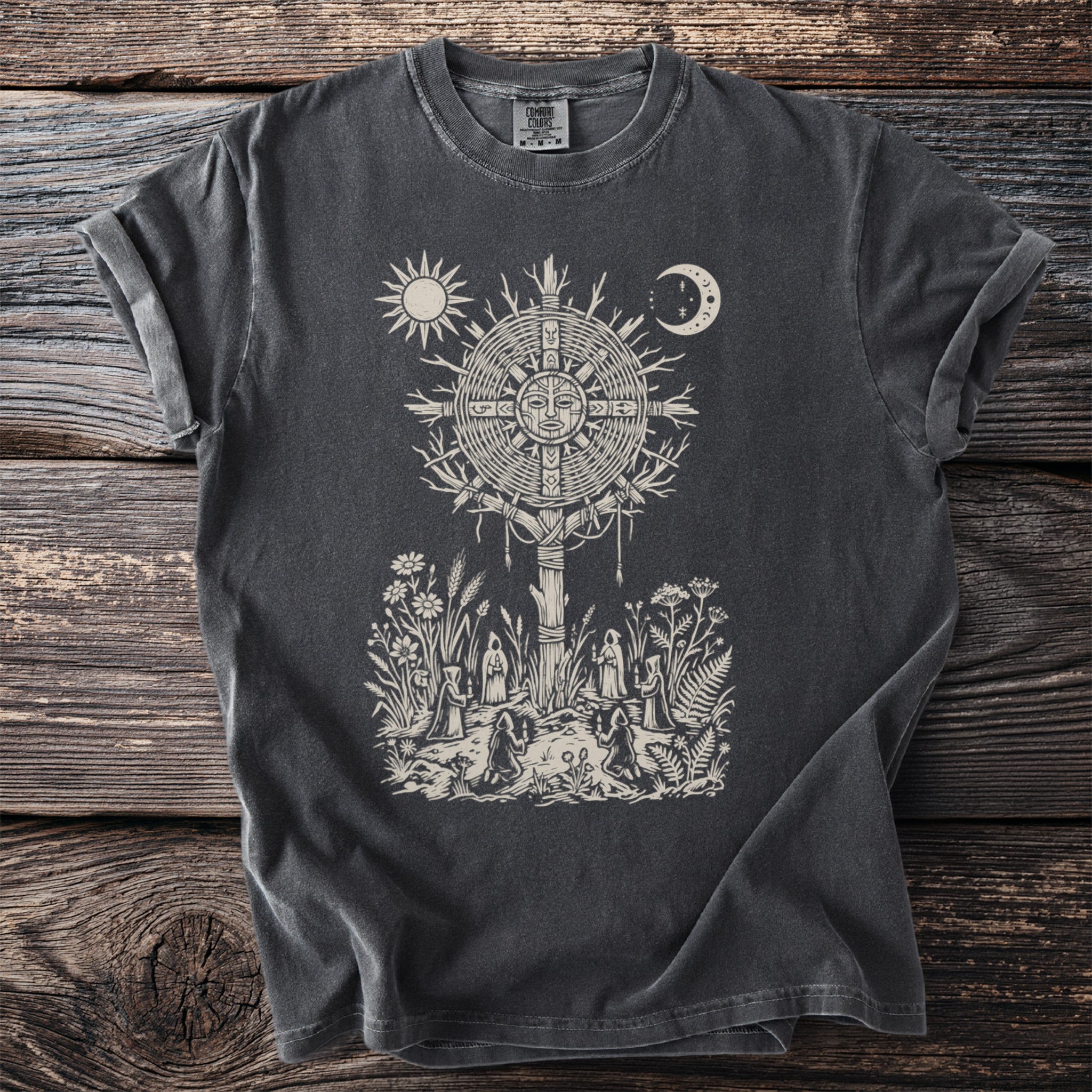 Dark t-shirt with a cream circular sun, moon, and people in robes.