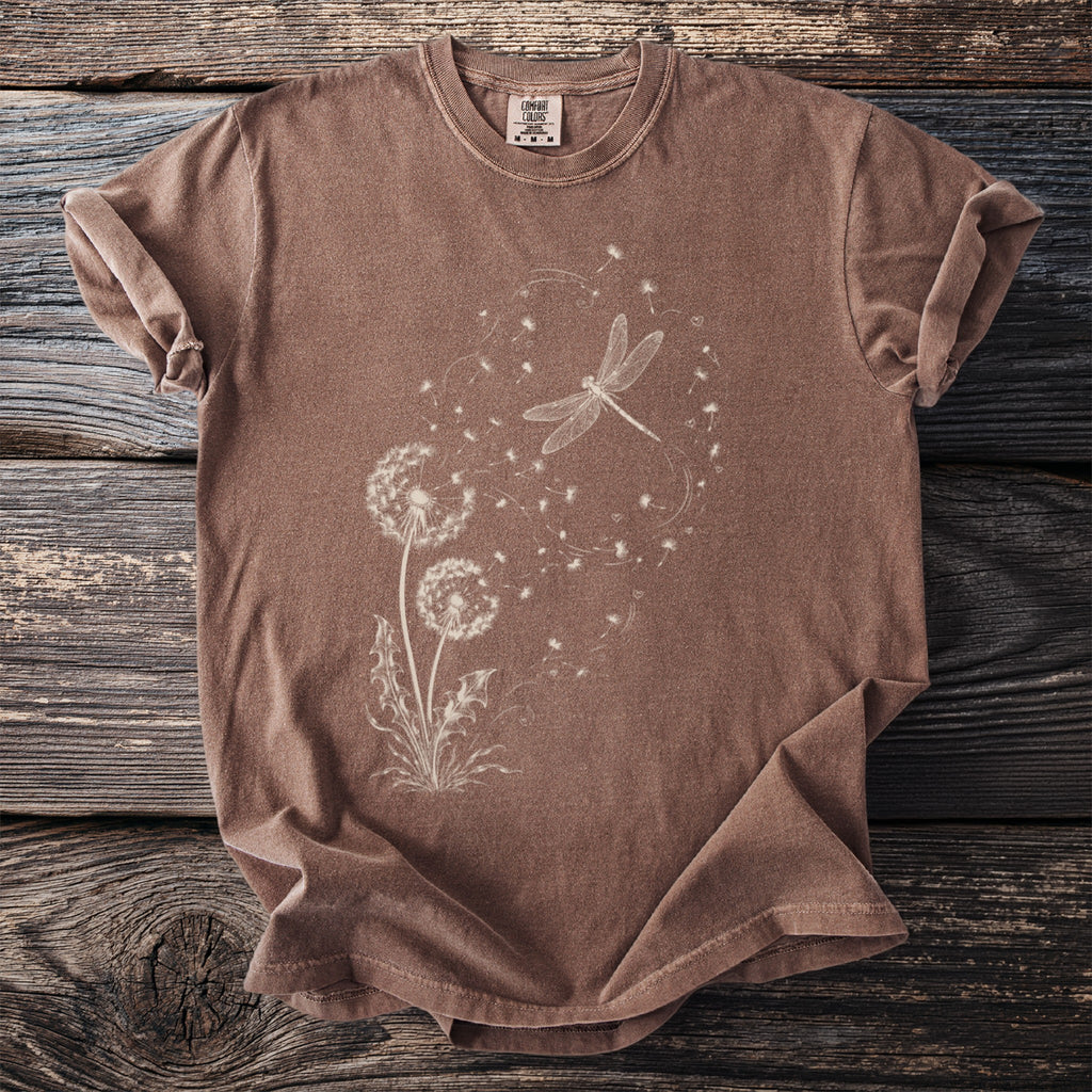 Brown t-shirt with a white dandelion and dragonfly graphic and Comfort Colors tag.