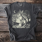 Dark t-shirt with vintage style graphic of a rabbit on a tombstone under a crescent moon.