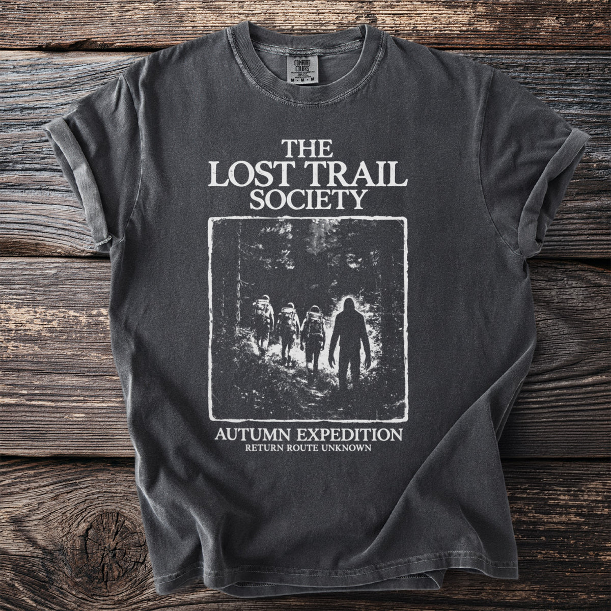 T-shirt with "The Lost Trail Society" and a forest scene with hikers and a figure.