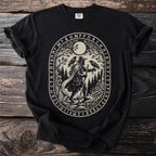 Black t-shirt with an oval print of a figure with two ravens and woodland scene.