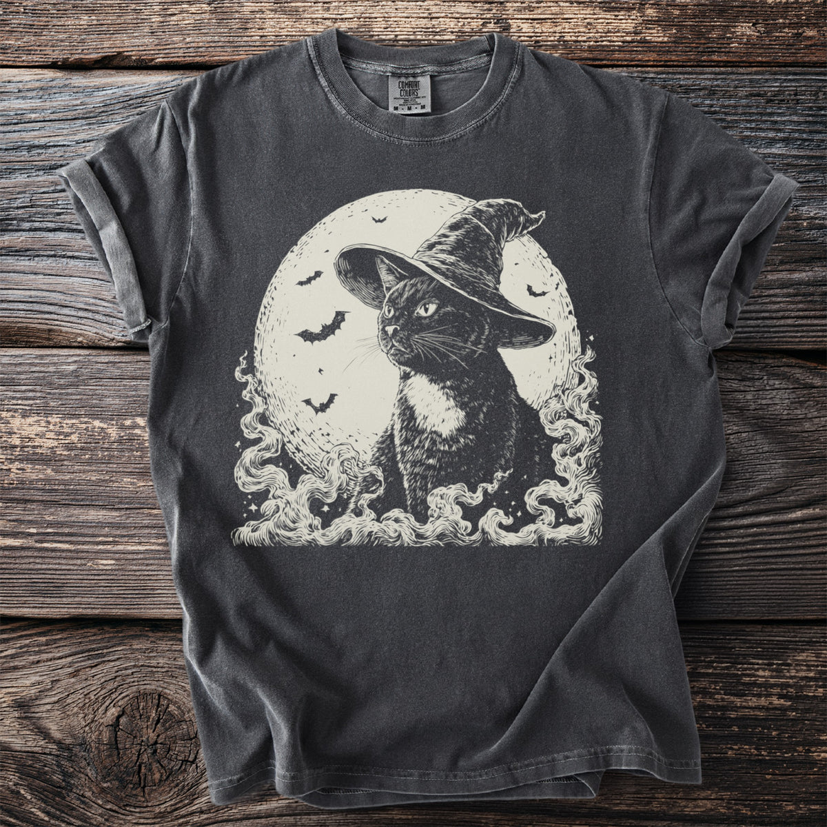 Black cat wearing a witch hat with a moon and bats behind it.