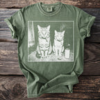 T-shirt with graphic of two cats sitting and smoking with a can of soda.