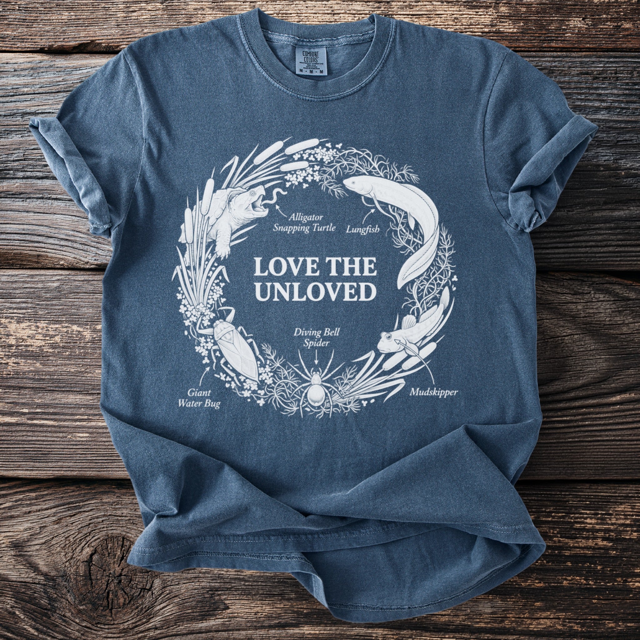 Blue t-shirt with "Love the Unloved" and illustrations of unloved creatures.