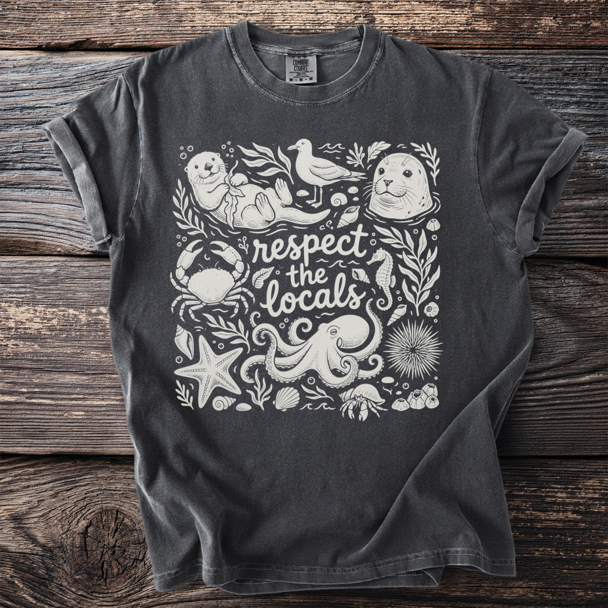 Dark t-shirt with white marine life illustration and text "respect the locals".