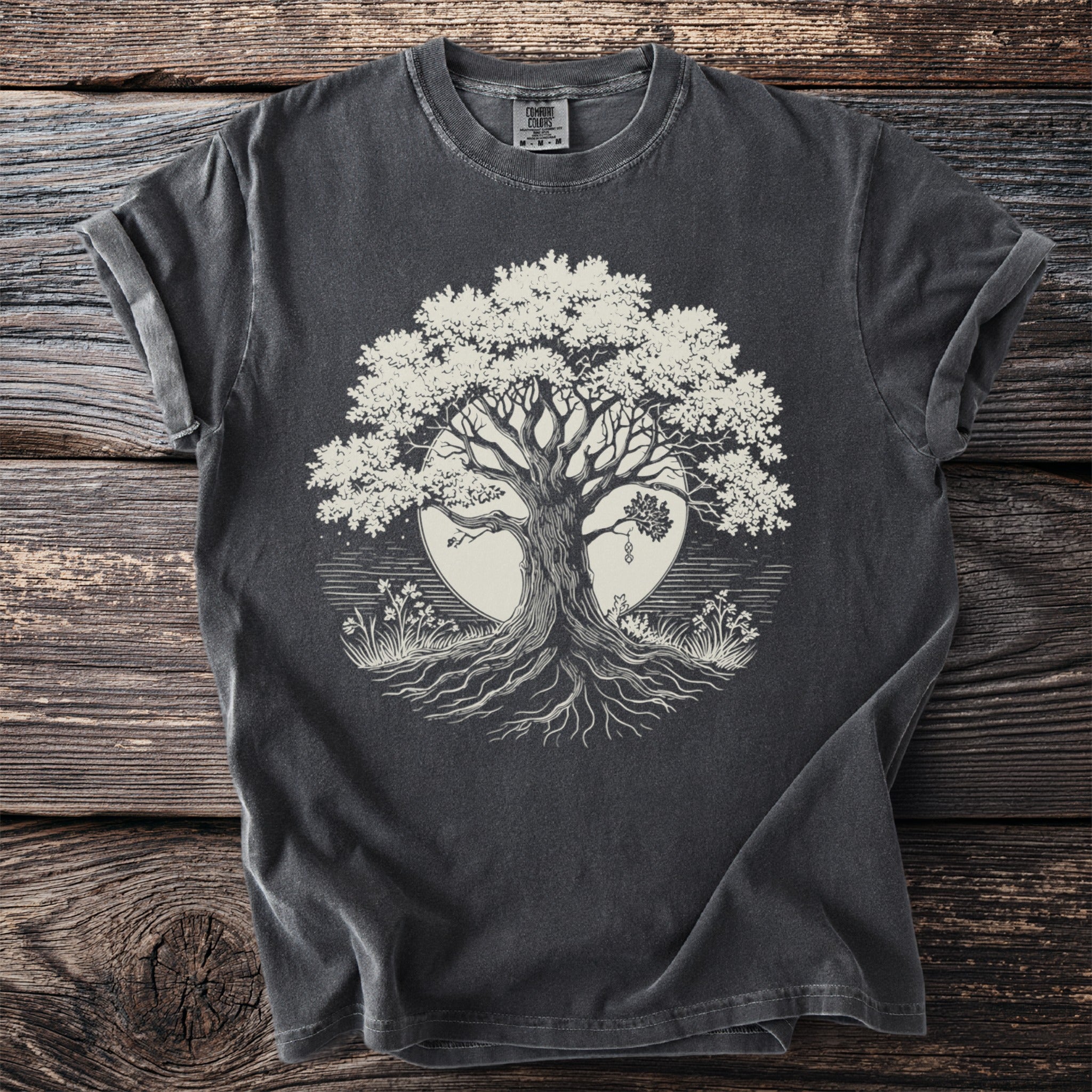 Dark grey t-shirt with a cream-colored tree of life graphic on a circular background.