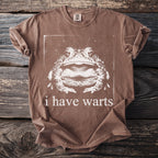 Brown t-shirt with a graphic of a toad and the text "i have warts."