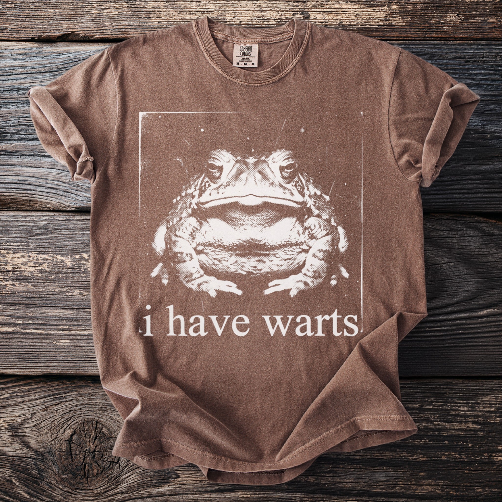 Brown t-shirt with a graphic of a toad and the text "i have warts."