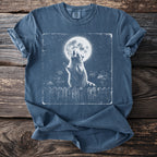 Blue t-shirt with a graphic of raccoons howling at the moon on a fence.