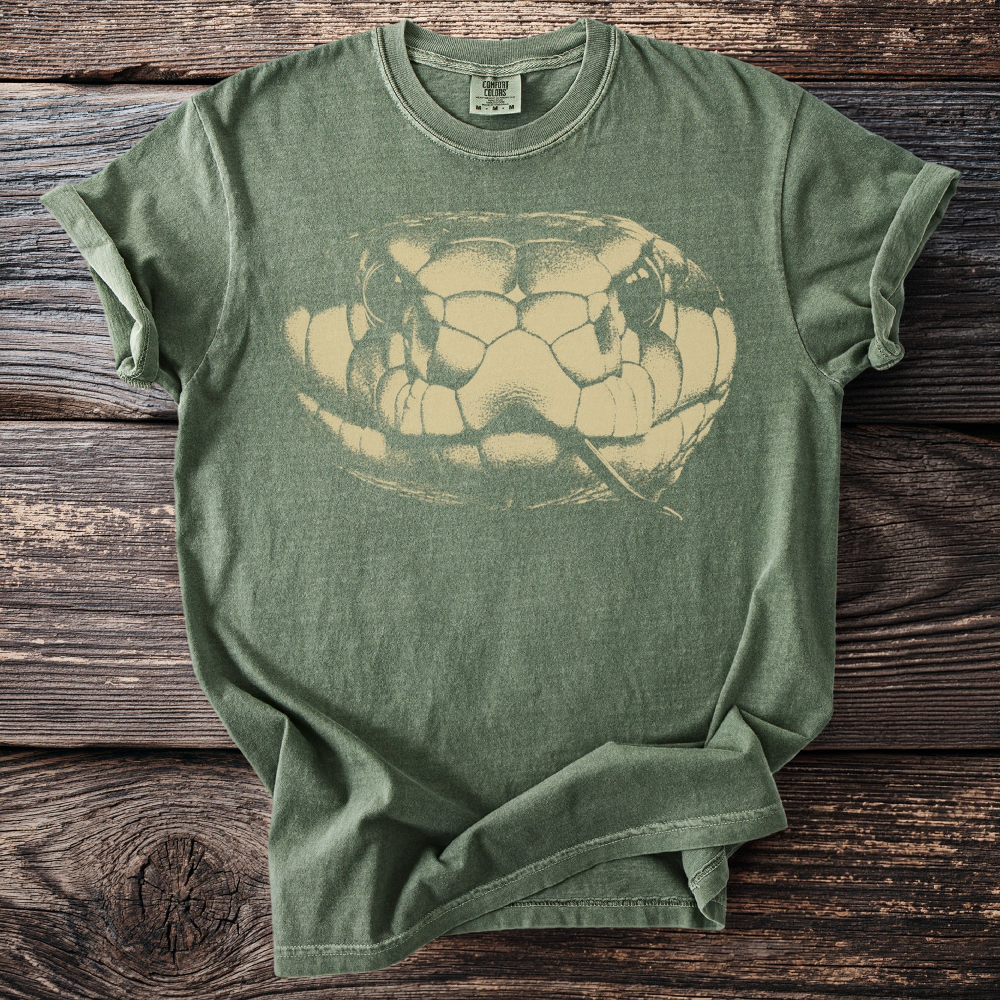 Green t-shirt with faded snake head graphic and "Comfort Colors" tag.