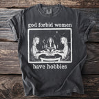 Dark grey t-shirt with "God forbid women have hobbies" and Ouija board graphic.
