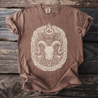 Brown t-shirt with a cream-colored graphic of a ram skull, crescent moon, and runes.